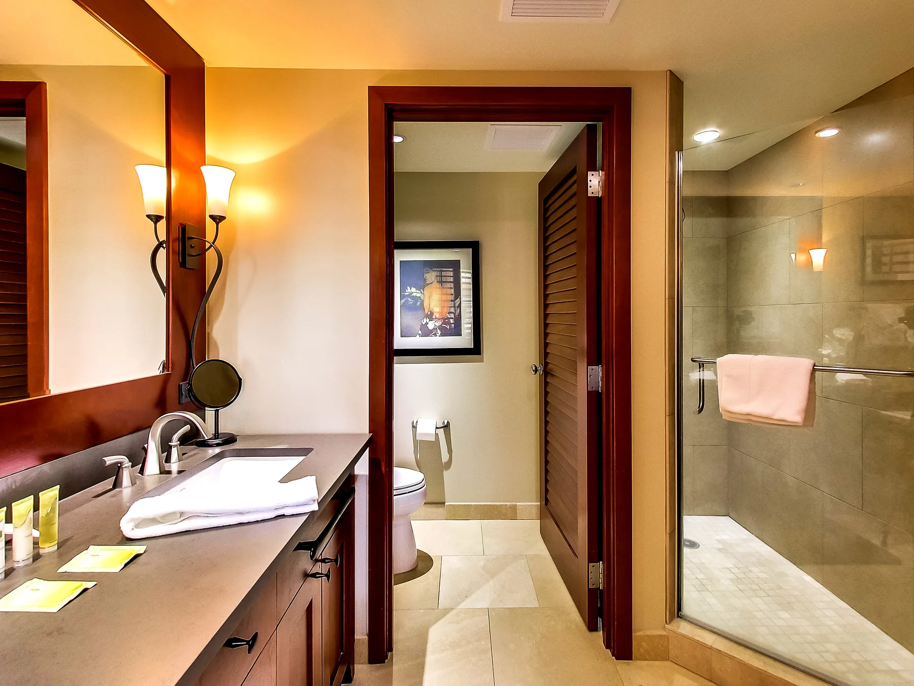 A bathroom vanity and sink sit beside a walk-in shower and open doorway.
