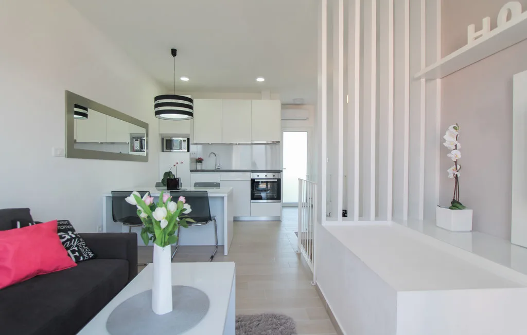 Una luminosa sala de estar de planta abierta y cocina con una mesa de comedor.