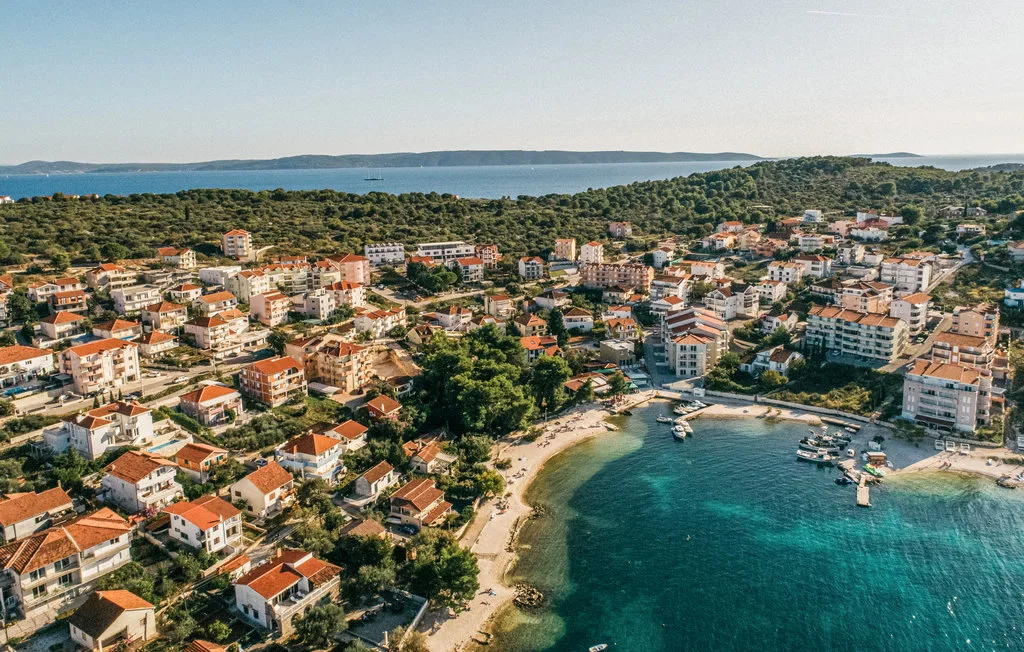Vista aérea de un pueblo costero junto a una bahía curva.