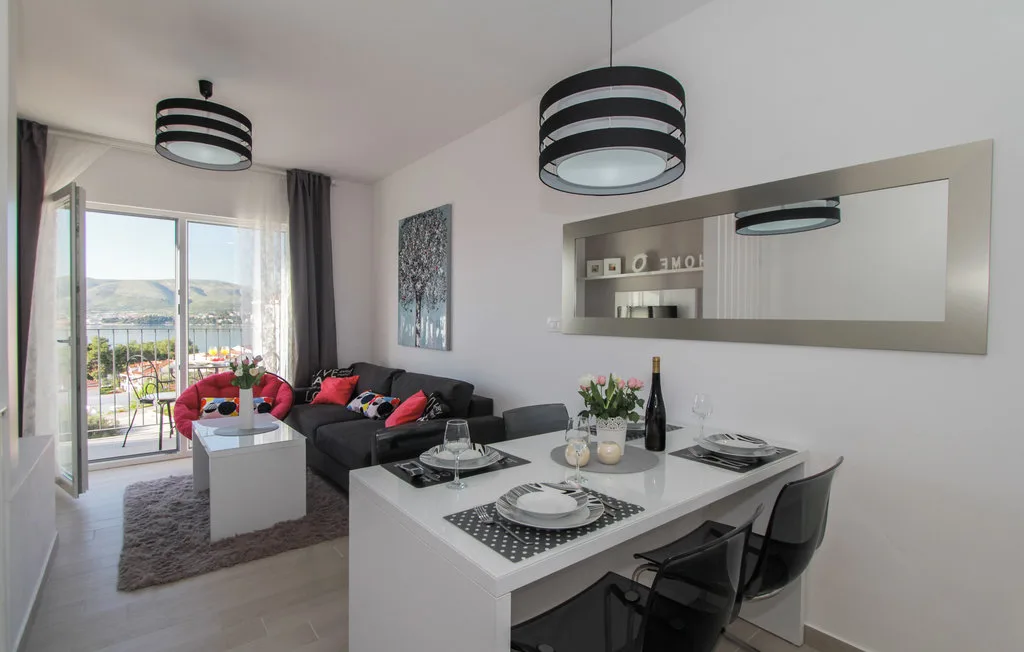 Una luminosa sala de estar y comedor diáfanos con una mesa junto a la zona de asientos.