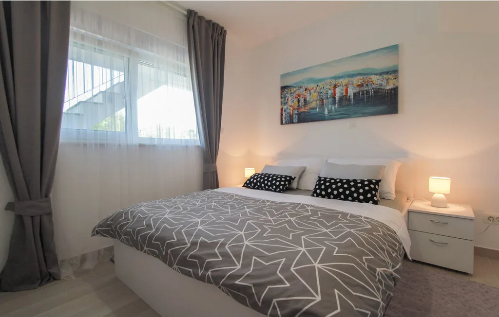Un dormitorio con una cama doble bajo un cuadro colorido.