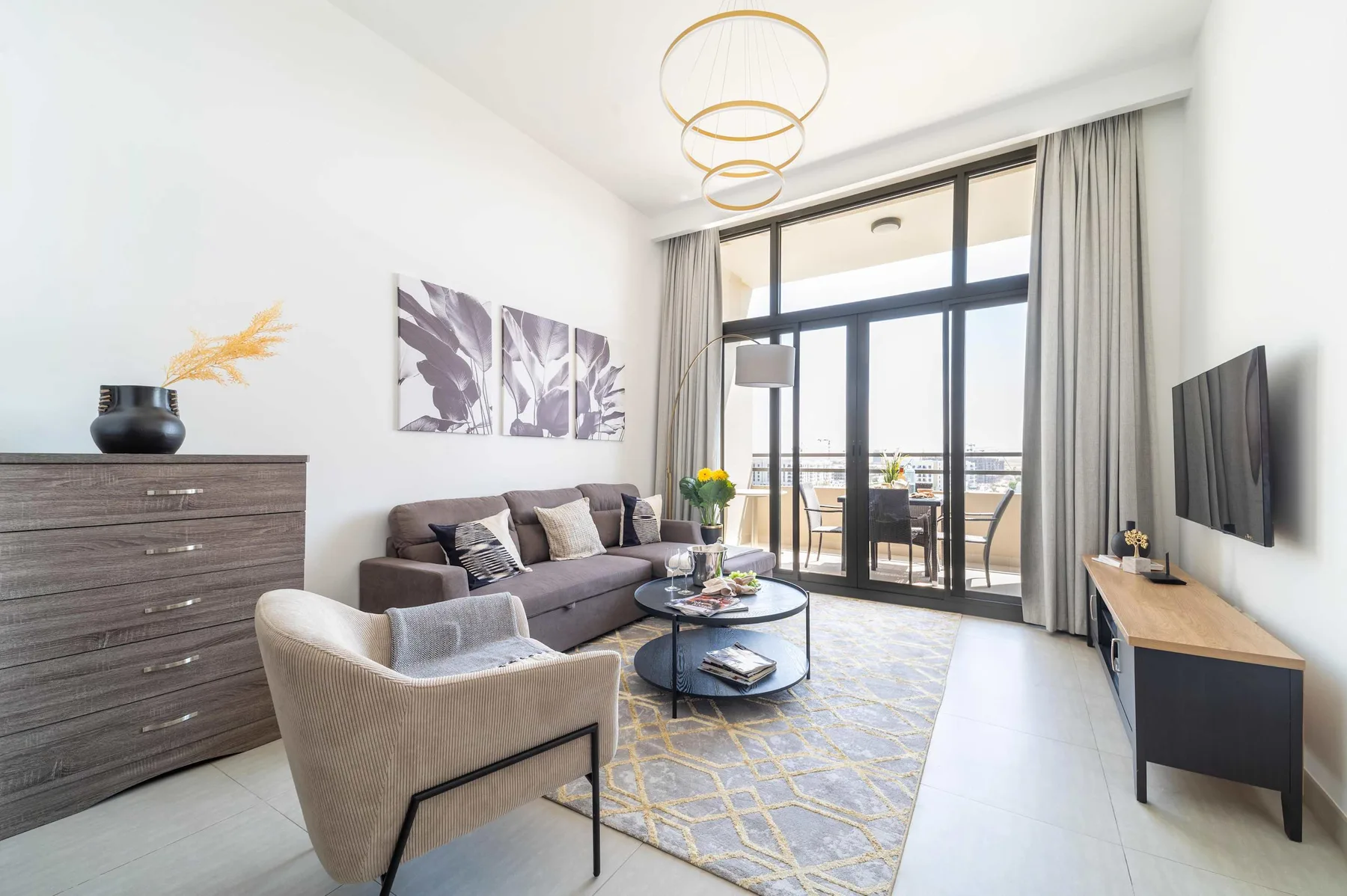 Sala de estar con asientos y puertas de vidrio hacia un balcón.