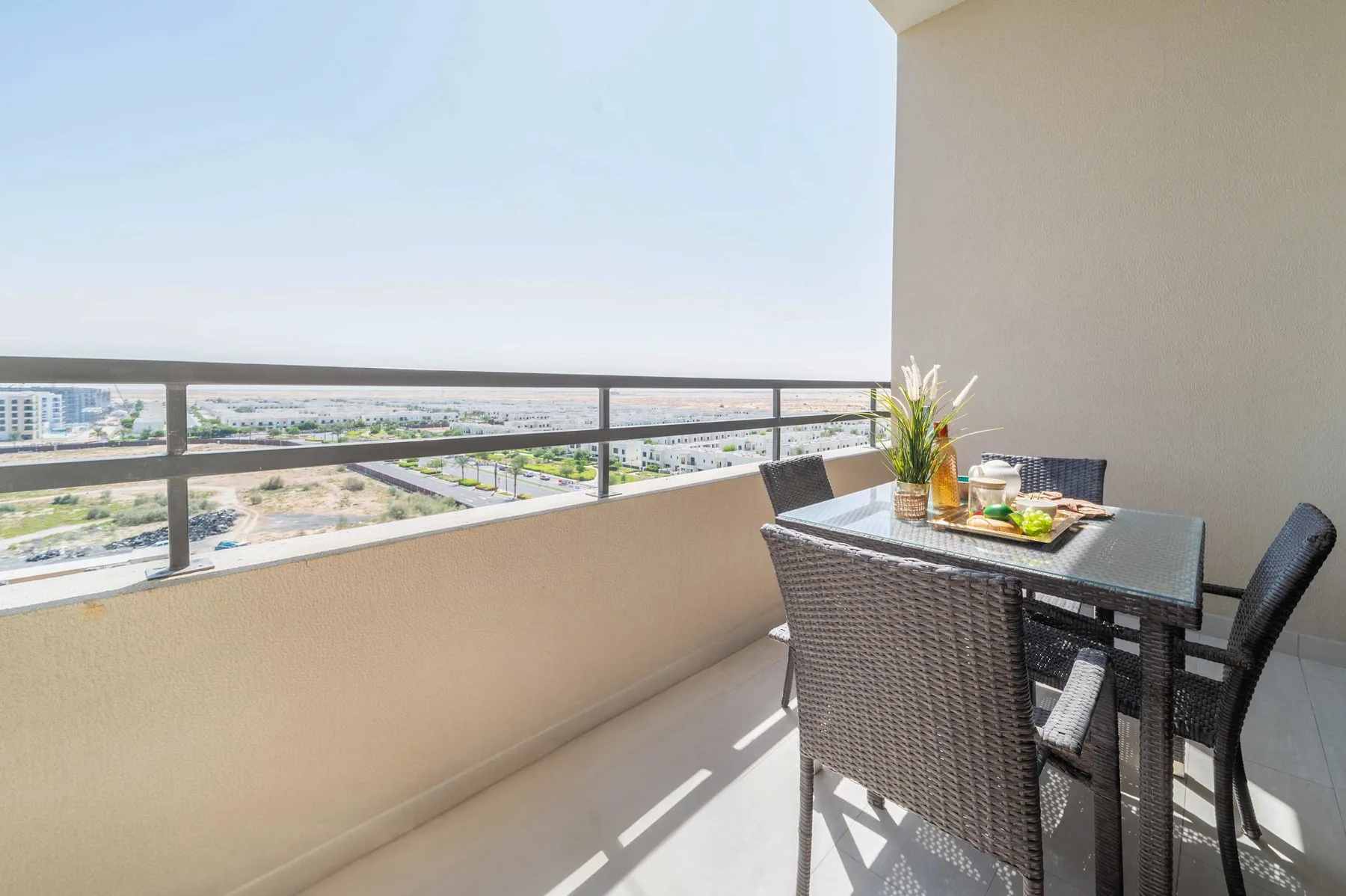 Una zona de comedor en el balcón, con mesa y asientos, da a la ciudad.