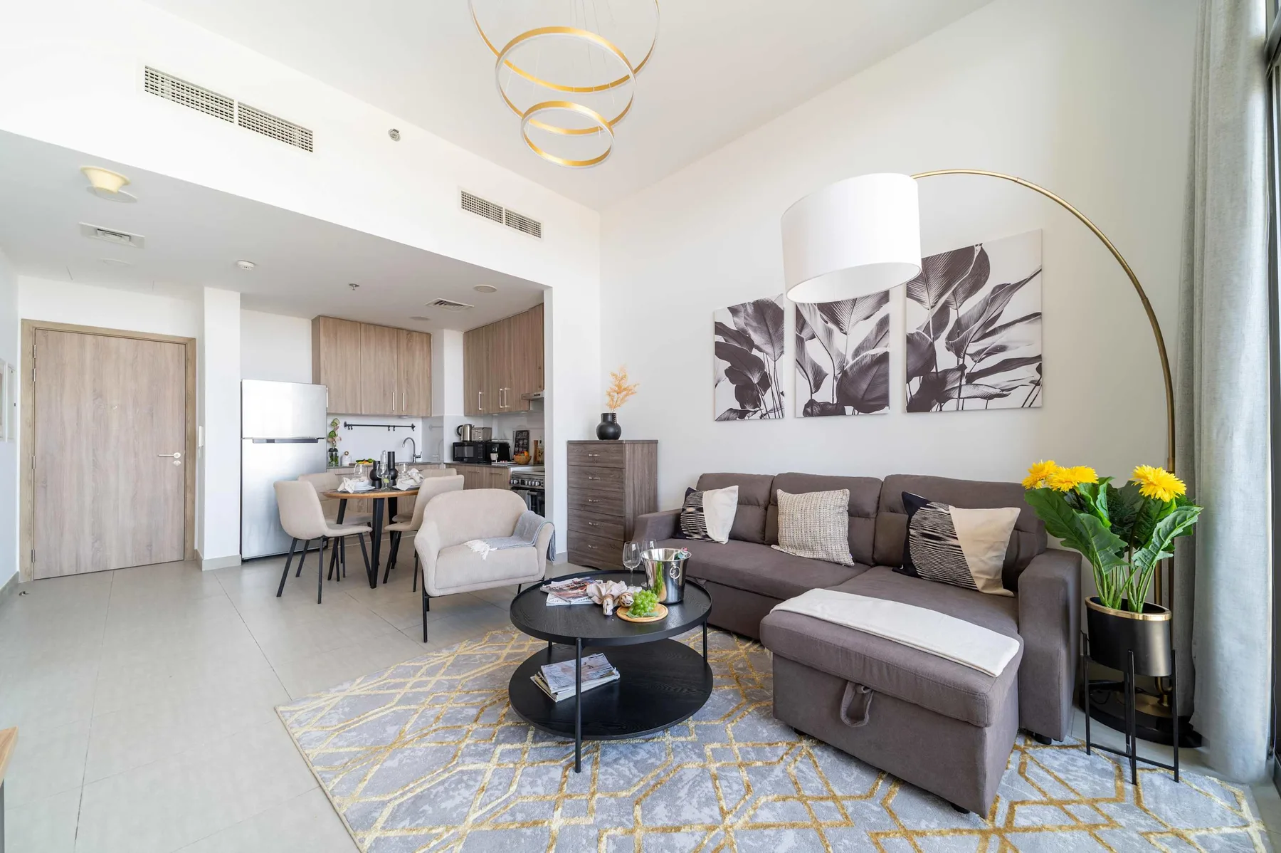 A bright living room with a sectional sofa, coffee table, and dining area.