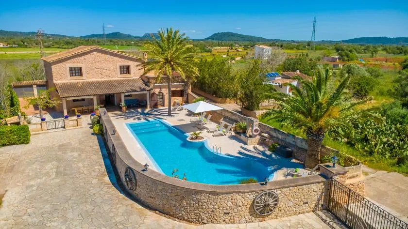 A countryside villa and a swimming pool surrounded by greenery.