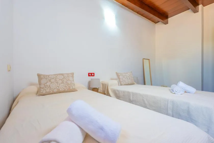 A bedroom with two beds and folded towels.