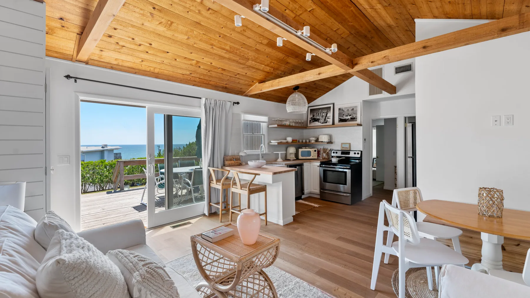 An open-plan kitchen and dining area with sliding glass doors opening onto a deck.