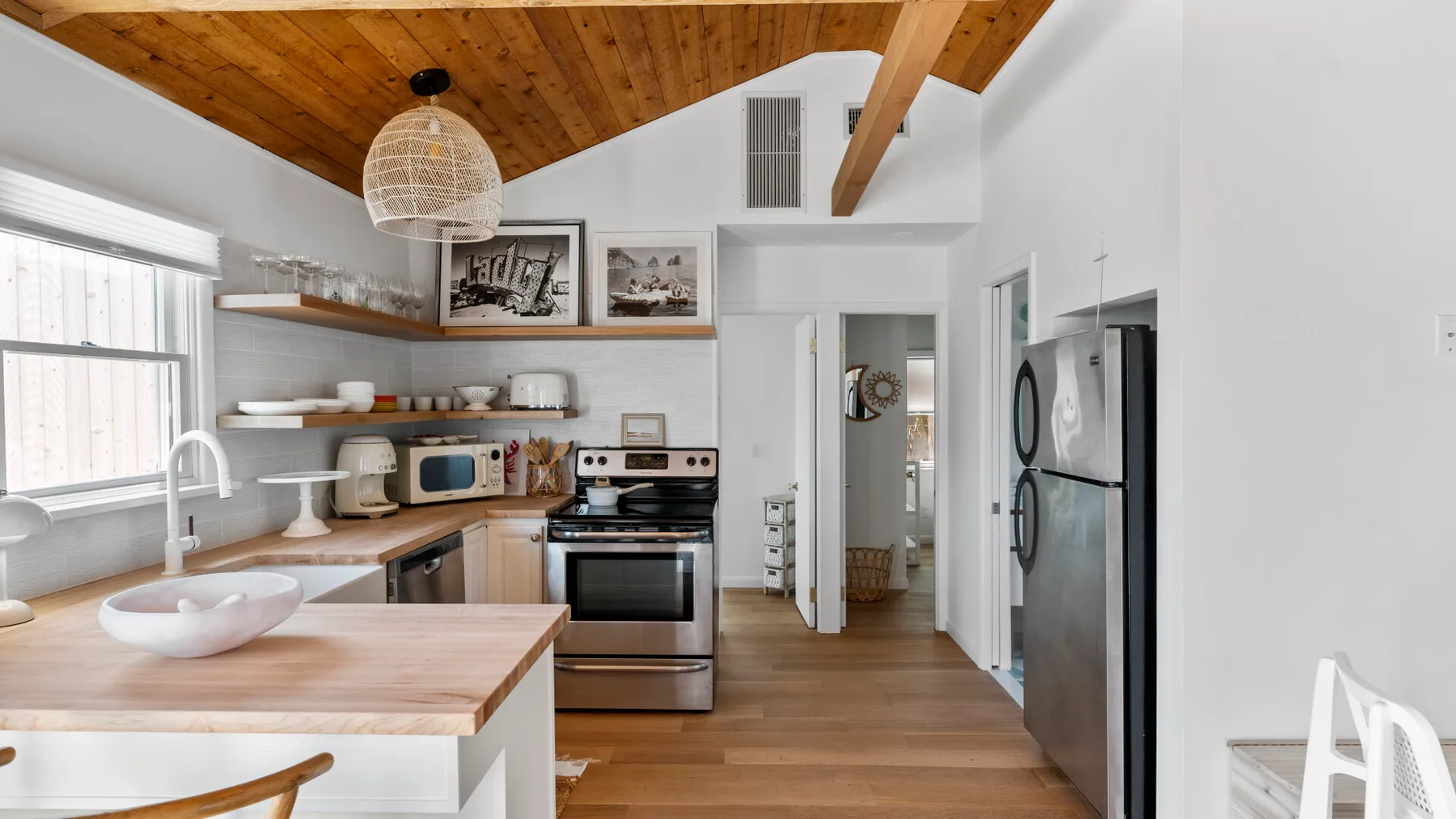 A bright kitchen with a wood countertop and stainless steel appliances.