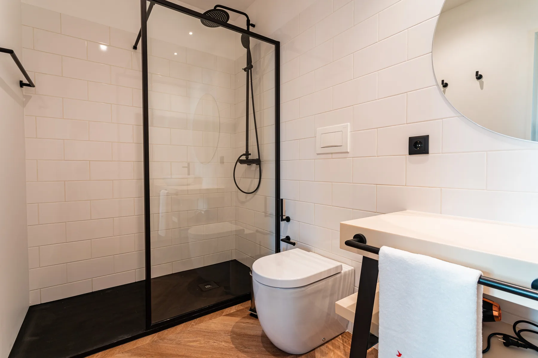 Un baño moderno con ducha de vidrio, inodoro y lavabo.