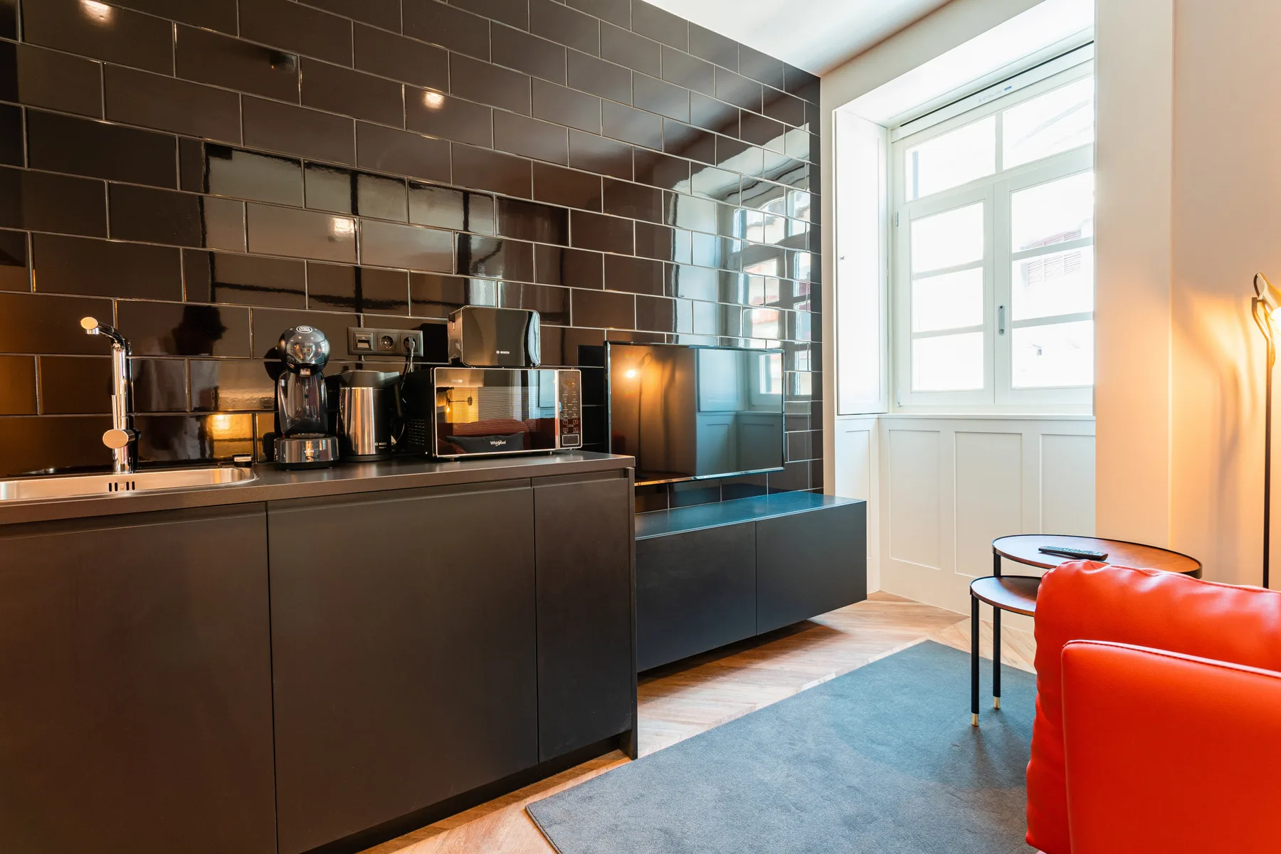 Una cocina moderna con gabinetes oscuros y una ventana luminosa.