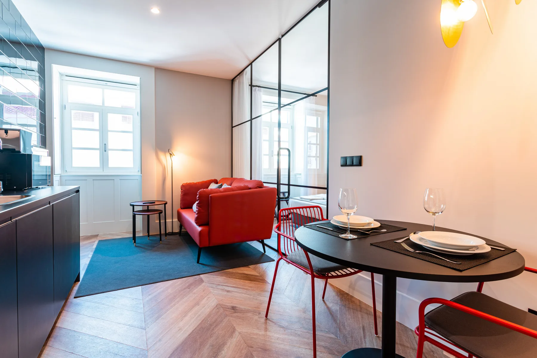 Una sala-comedor abierta con asientos rojos y una mesa puesta.
