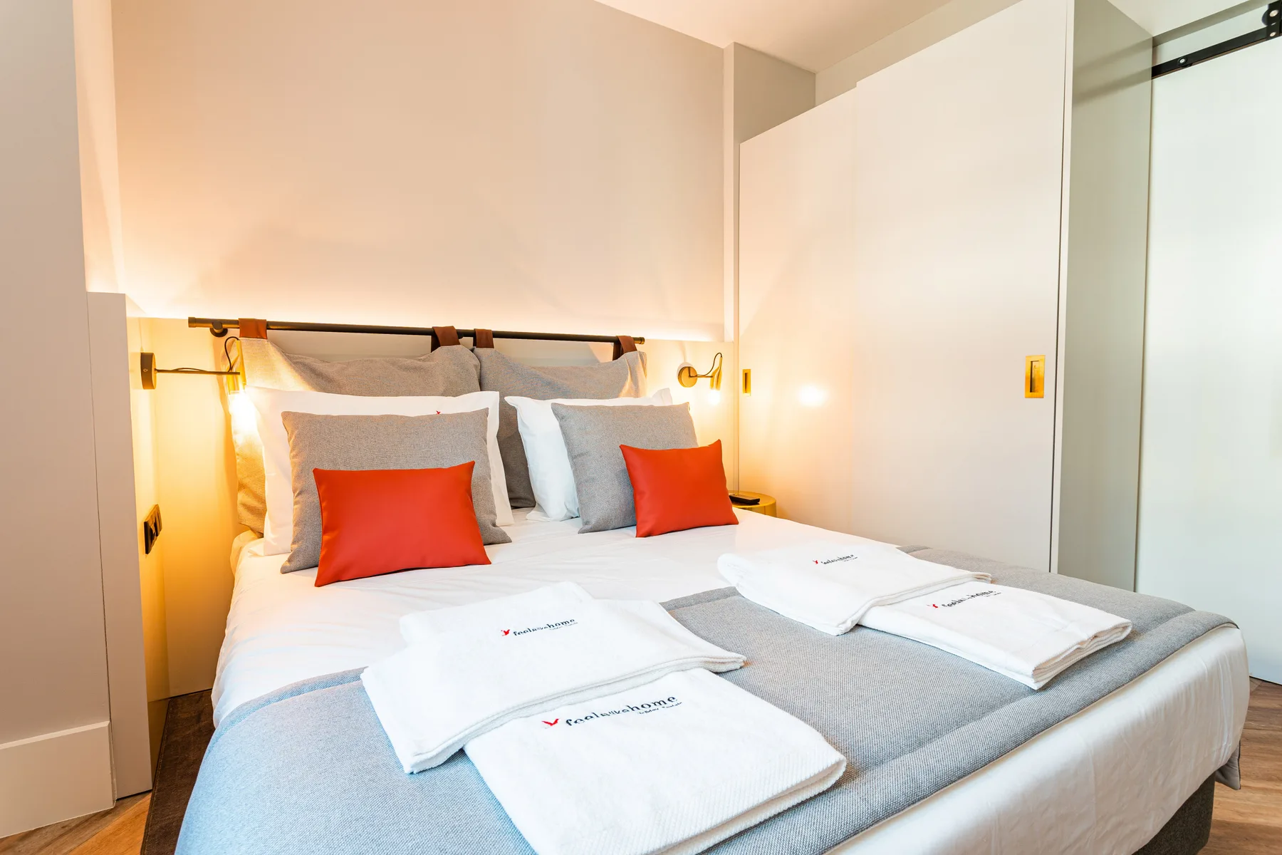 Dormitorio con una cama bien arreglada y ropa de cama blanca.