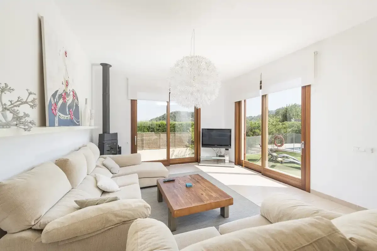 A bright living room with seating, a coffee table, and wide glass doors.
