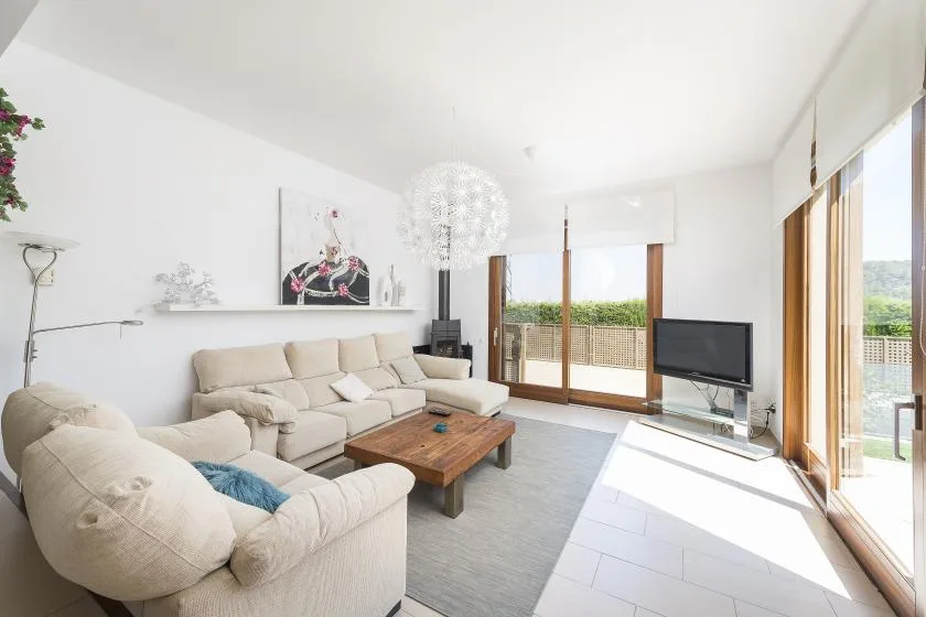 A bright living room with seating, a coffee table, and large windows.