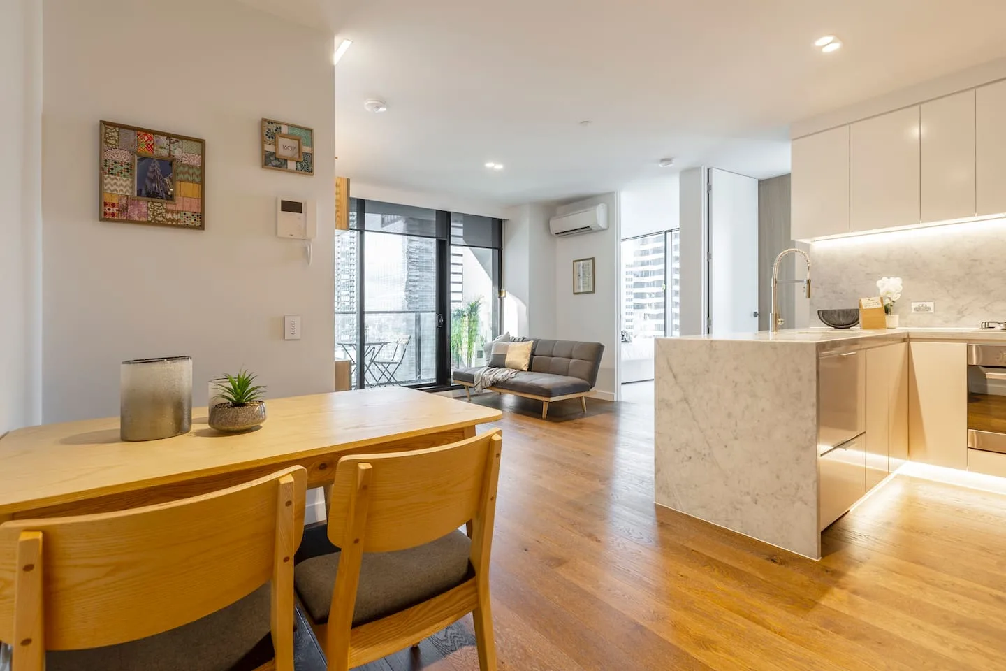 An open-plan living and dining area features a wooden dining table and seating.