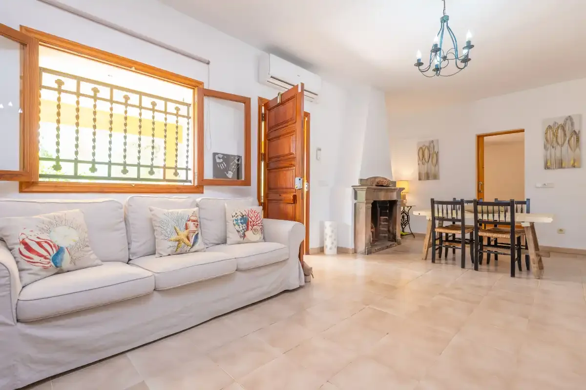 Una luminosa sala de estar y comedor con sofá, mesa y chimenea.