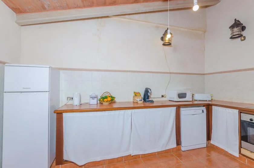 Una cocina con encimeras de madera, un refrigerador y pequeños electrodomésticos.