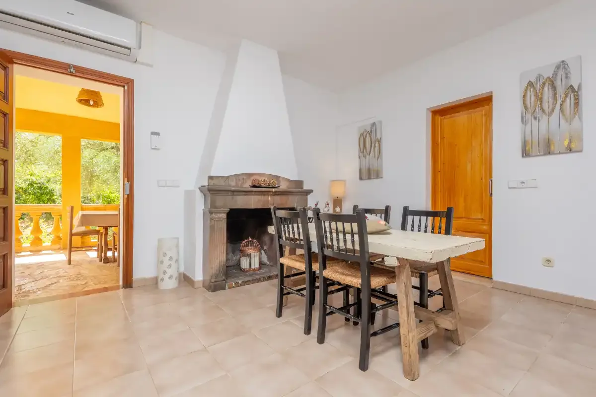 Un comedor con una mesa y sillas junto a una chimenea.
