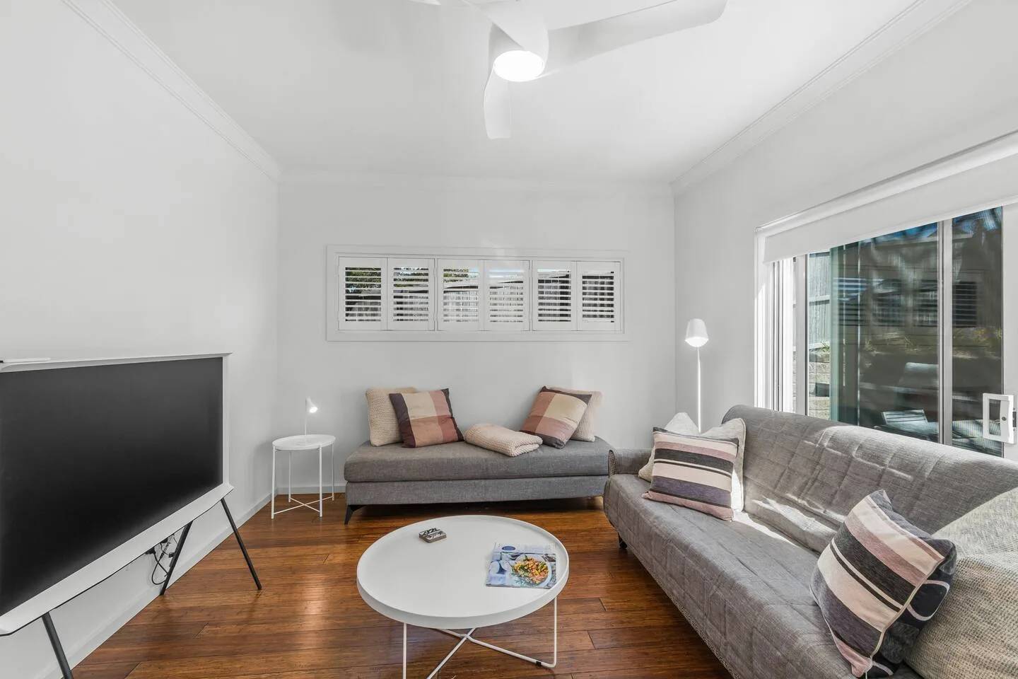 A living room with seating, a television, and a round coffee table.