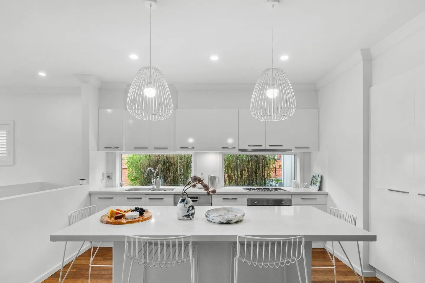 Gather around the kitchen island beneath pendant lighting, the perfect spot for morning coffees and casual meals.