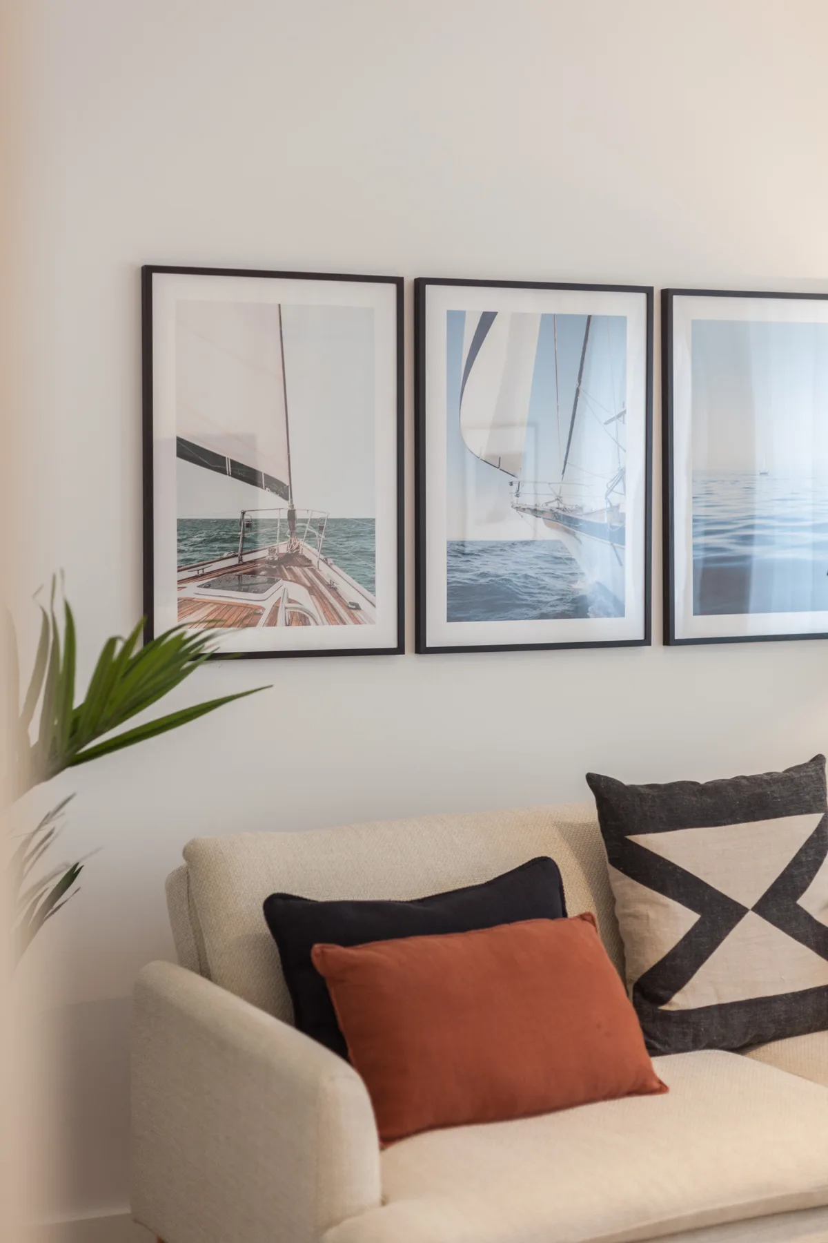 Asientos de sala con fotografías del mar enmarcadas y cojines decorativos.