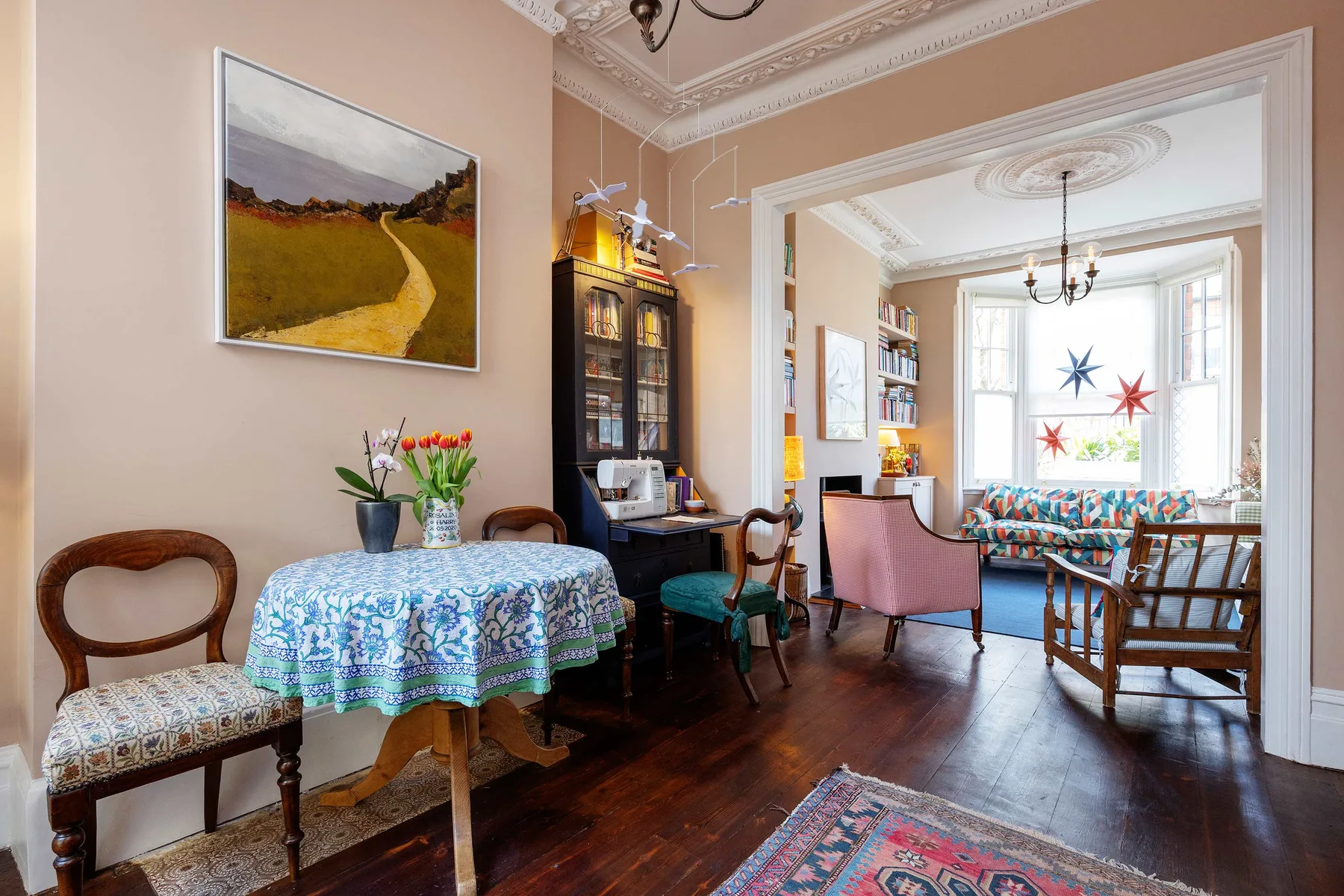 A dining area opens into a bright sitting room with a bay window.