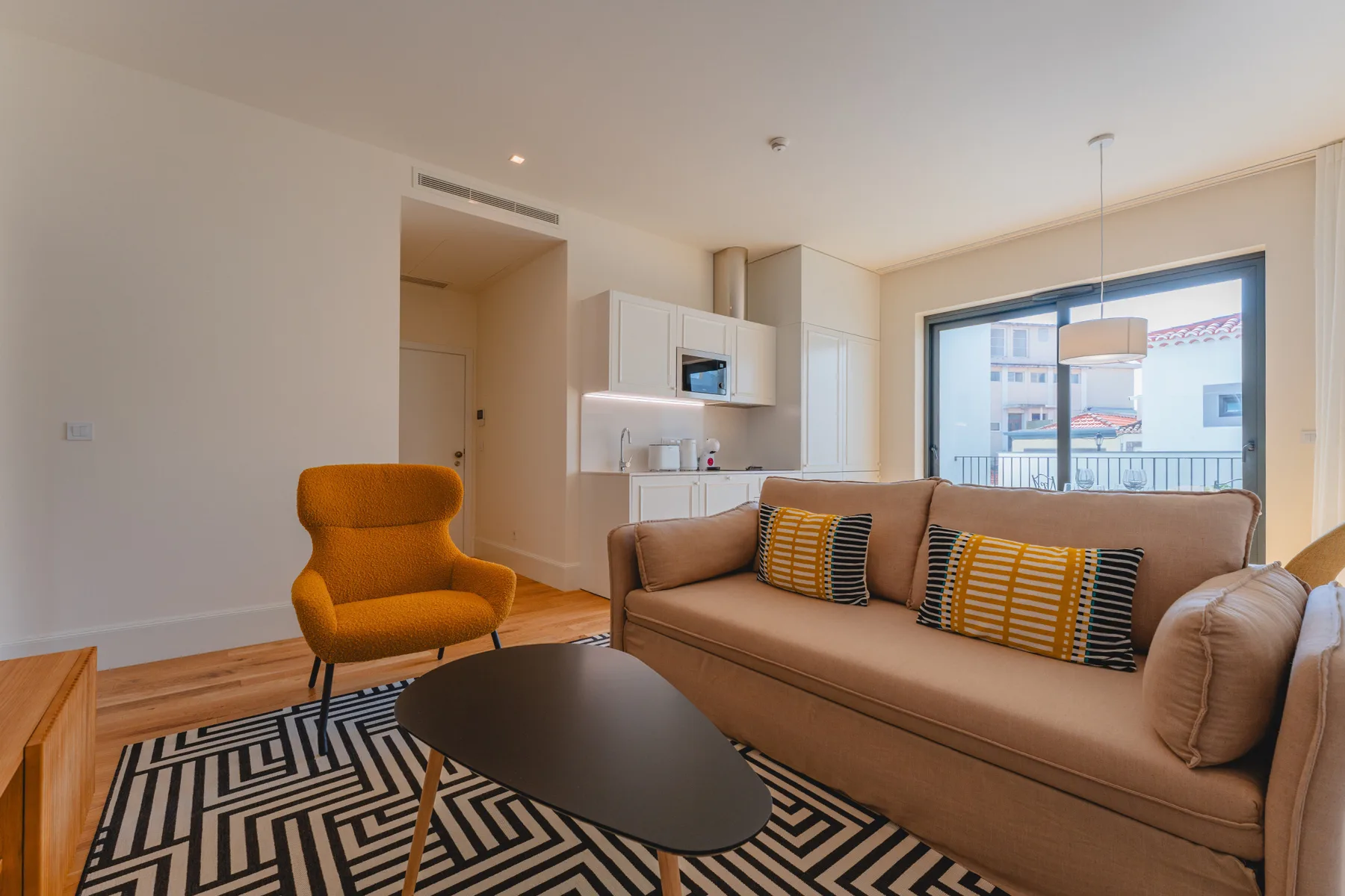 A living room with a sofa, an armchair, and a coffee table.