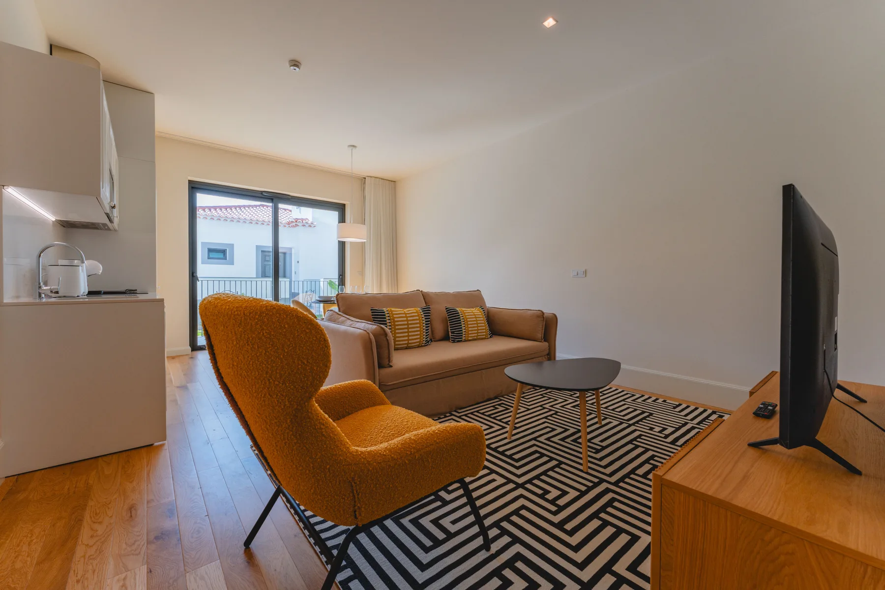 A living room with seating around a coffee table and a television.