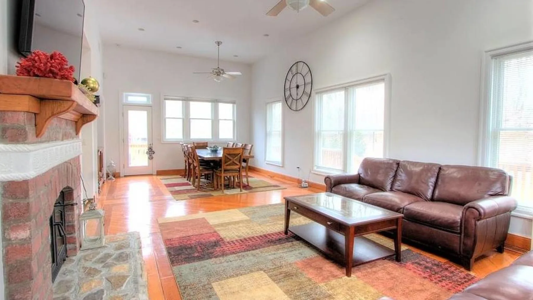 A bright living room with seating, a coffee table, and a dining area.