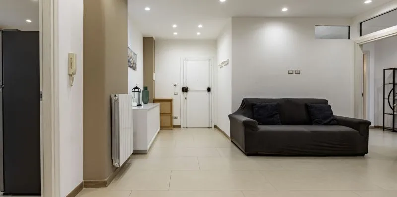 Una sala luminosa con asientos oscuros y piso de baldosas blancas.