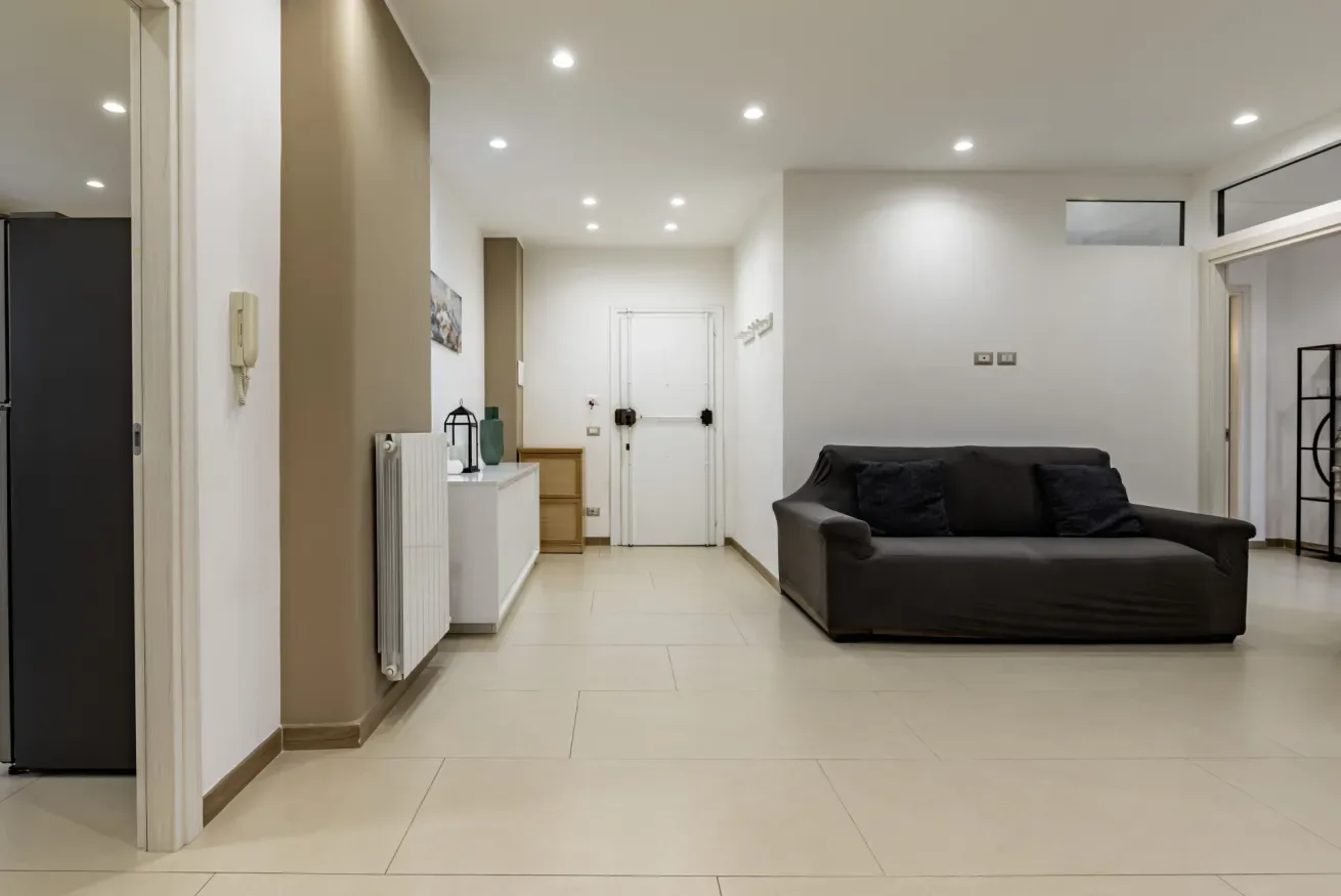 Una sala luminosa con asientos oscuros y una puerta blanca al fondo.