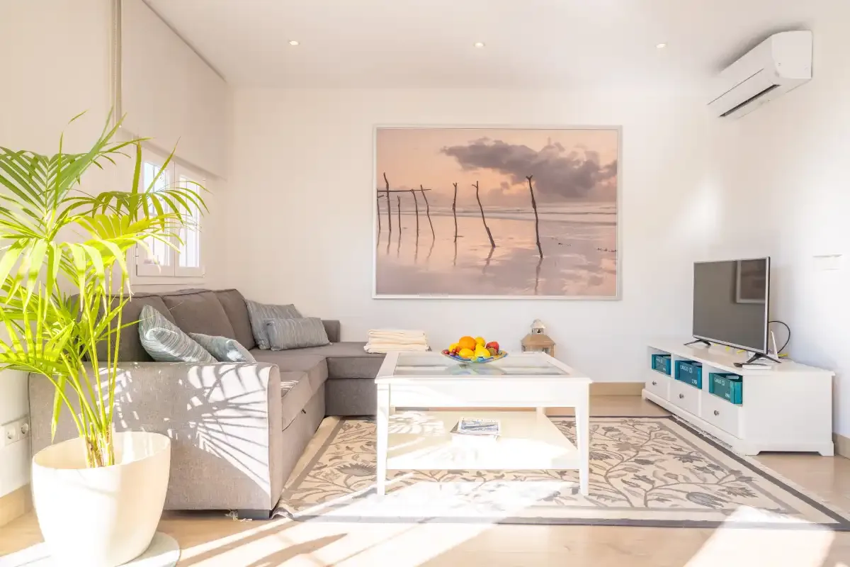 A bright living room with a sectional sofa, coffee table, and wall-mounted television.