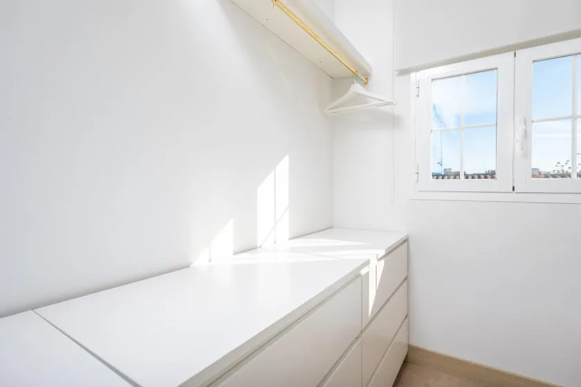 A bright room with a long built-in counter beneath a window.