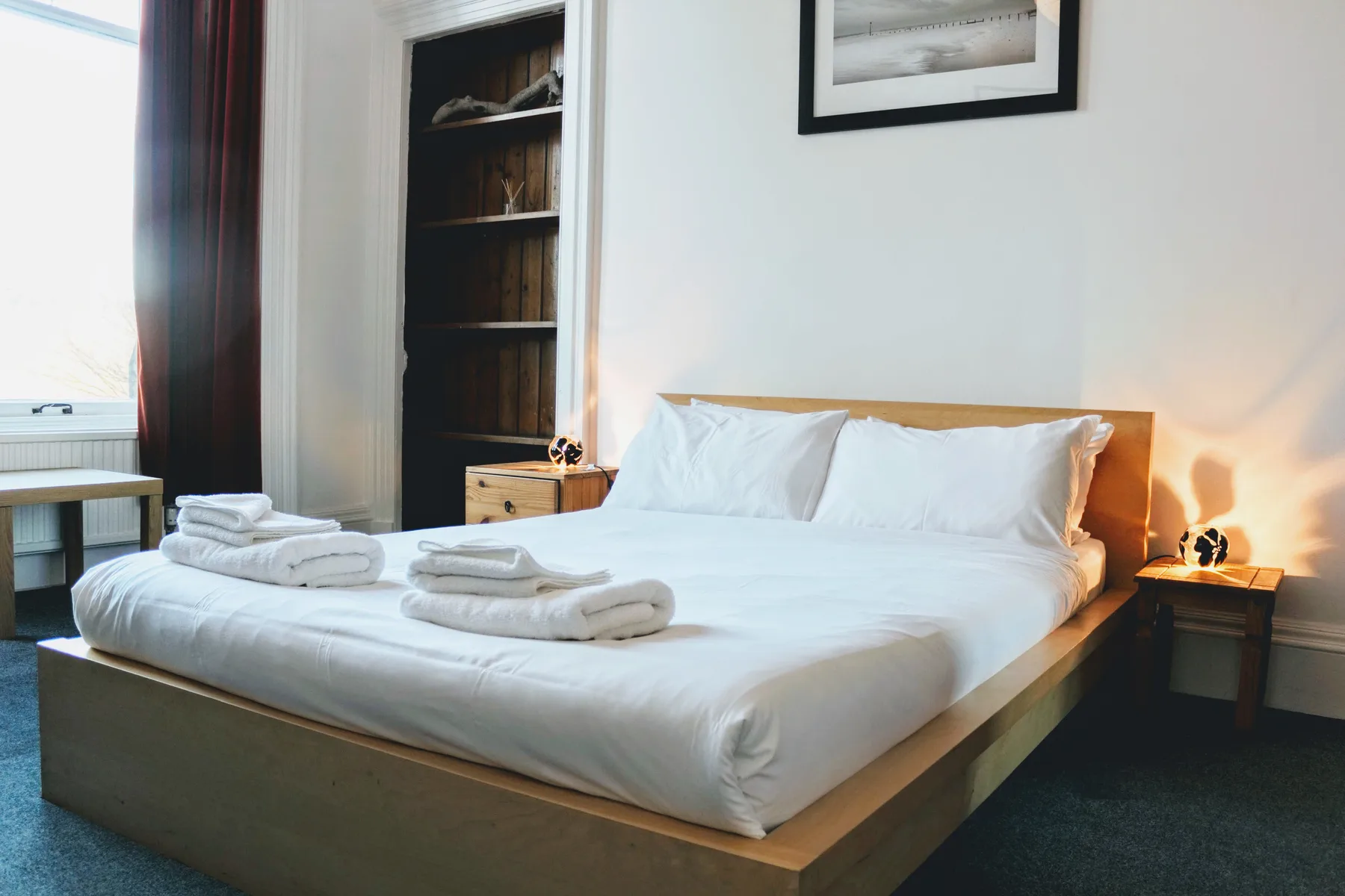 Un dormitorio con una cama bien tendida y toallas dobladas.