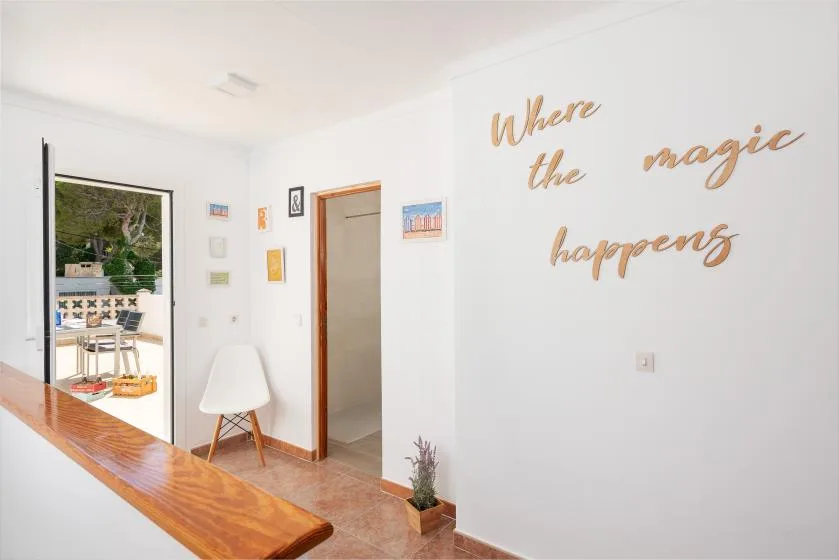 A bright interior hallway with a wooden counter and decorative wall lettering.