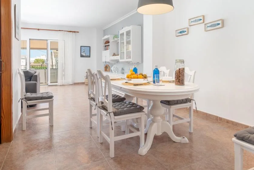 A dining area with a set table and chairs beside a bright living space.