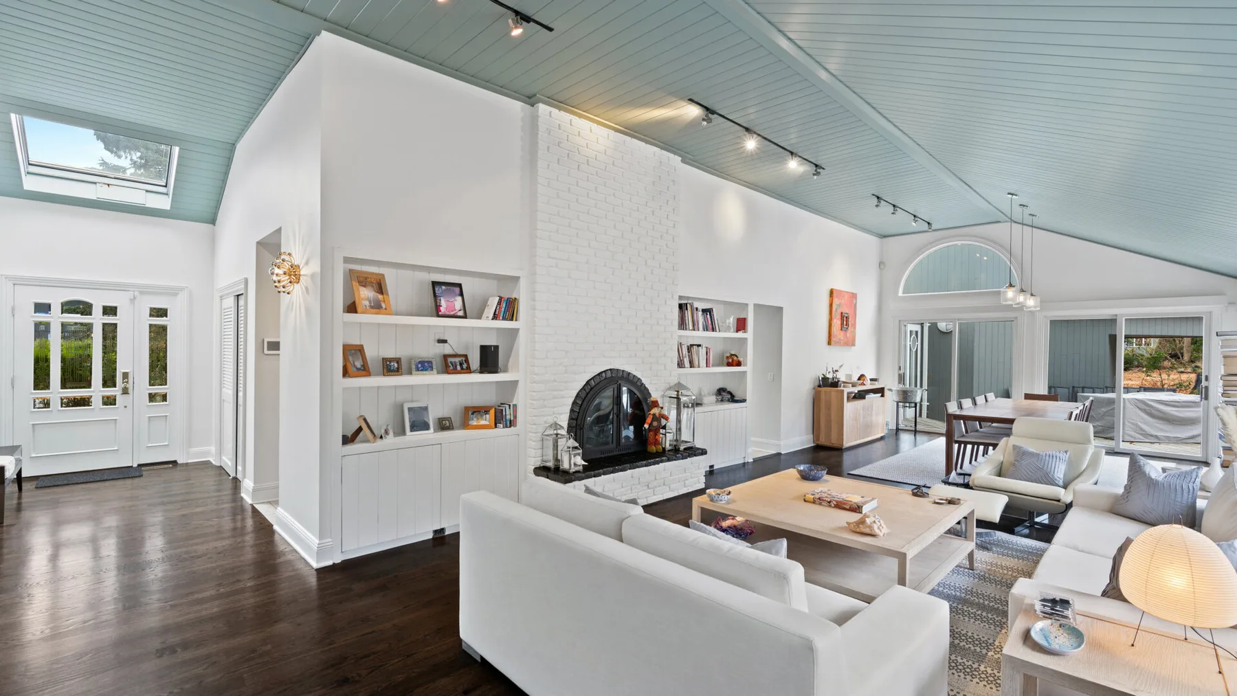 A bright living room with built-in shelves and seating around a coffee table.