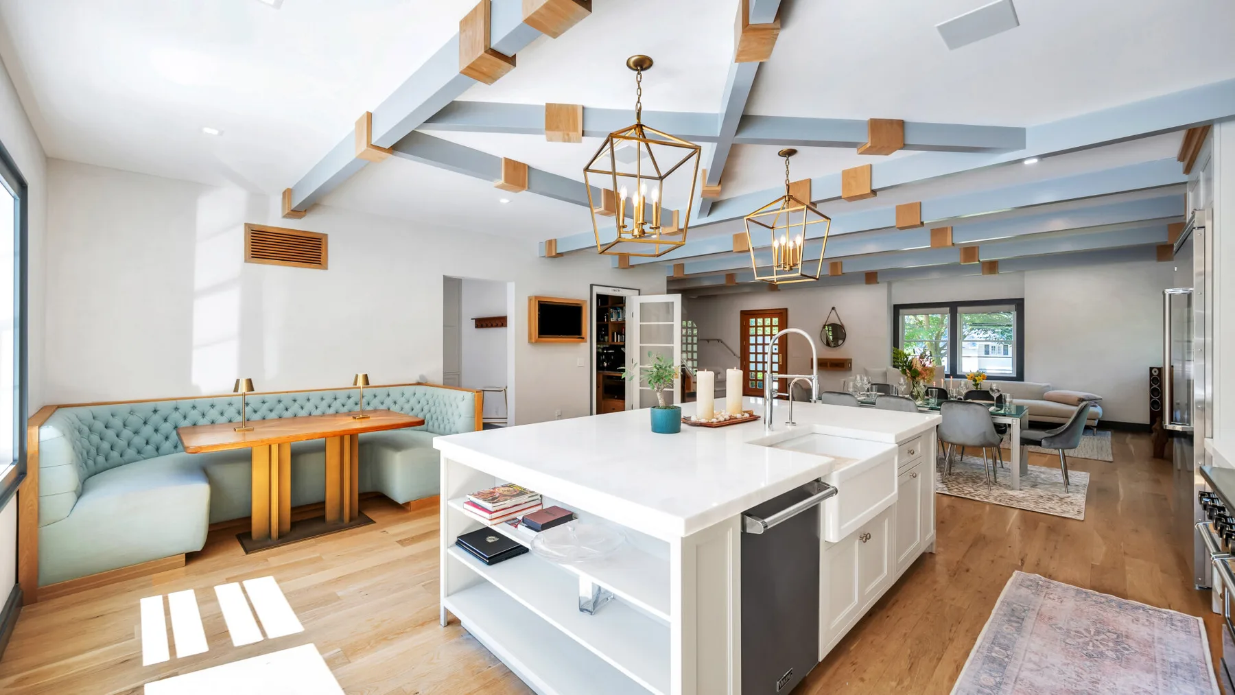 A bright open-plan kitchen and dining area features a large central island and seating.