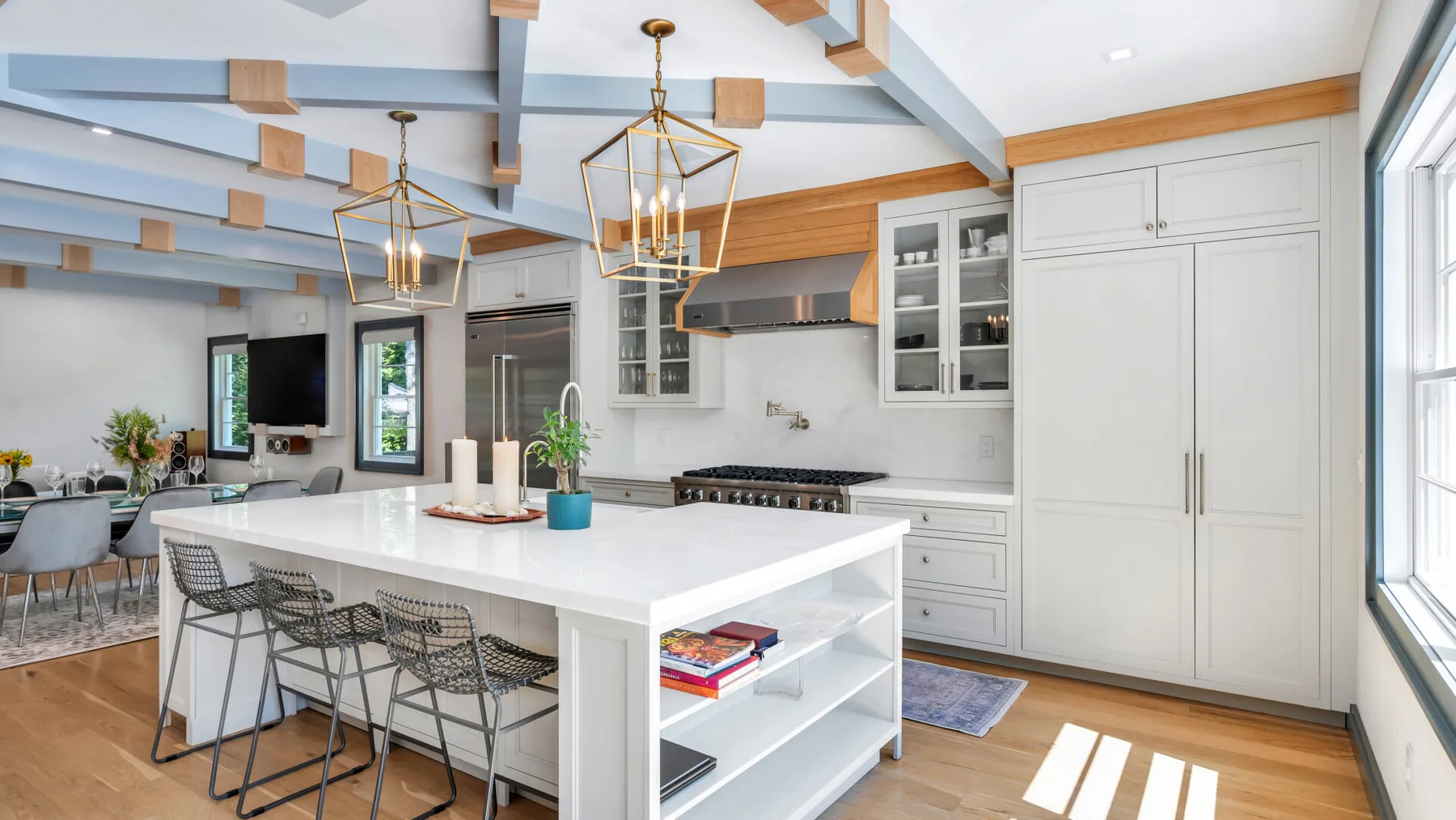 A bright kitchen with a large island, bar seating, and white cabinetry.