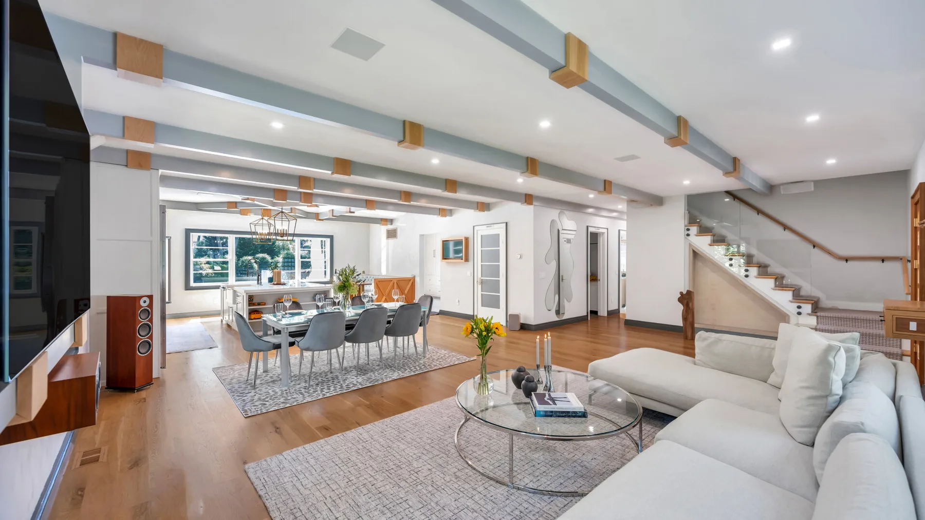 A bright open-plan living and dining area with seating around a glass coffee table.