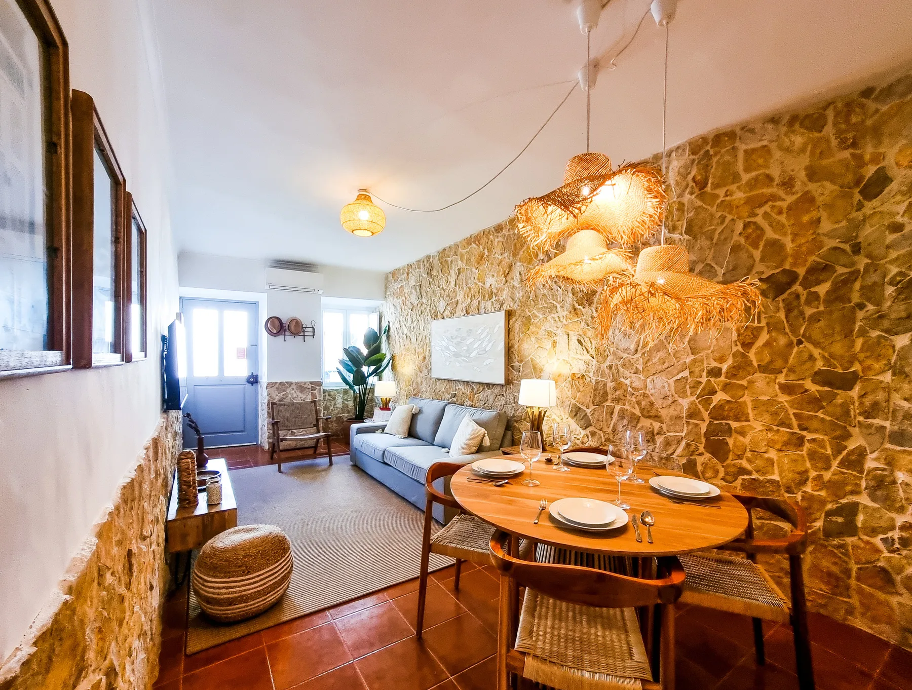 A living and dining room with a sofa and a set dining table.