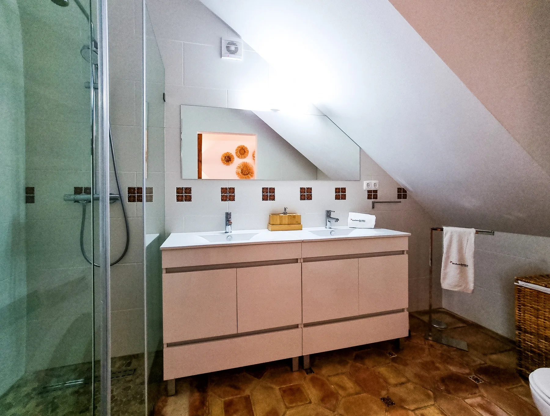 A bathroom with a double-sink vanity, mirror, and glass shower.