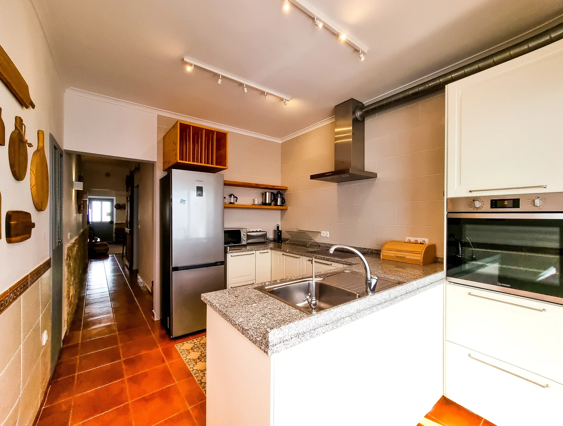 A kitchen with a central island, sink, and built-in oven.