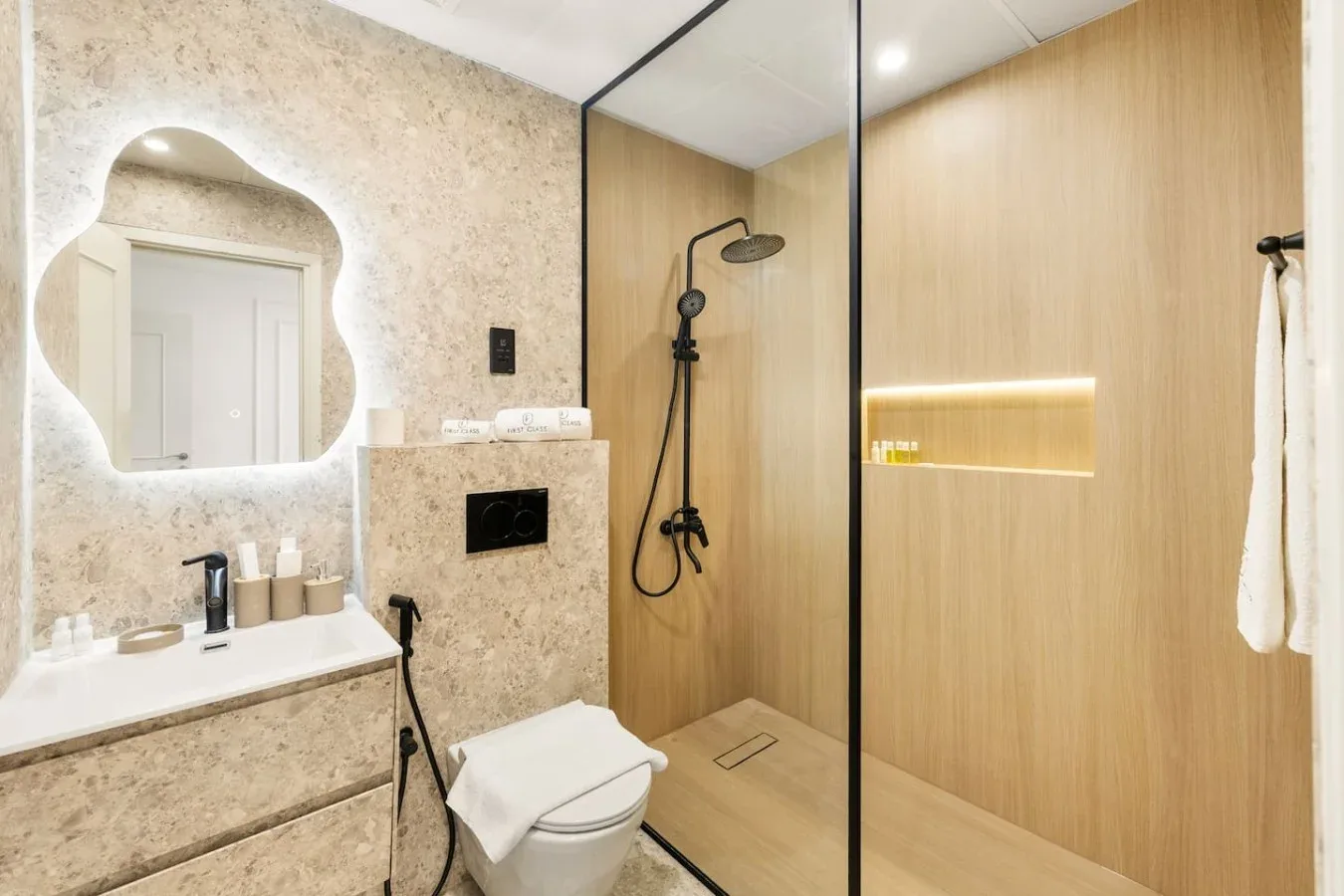 A modern bathroom with a sink, toilet, and walk-in shower.