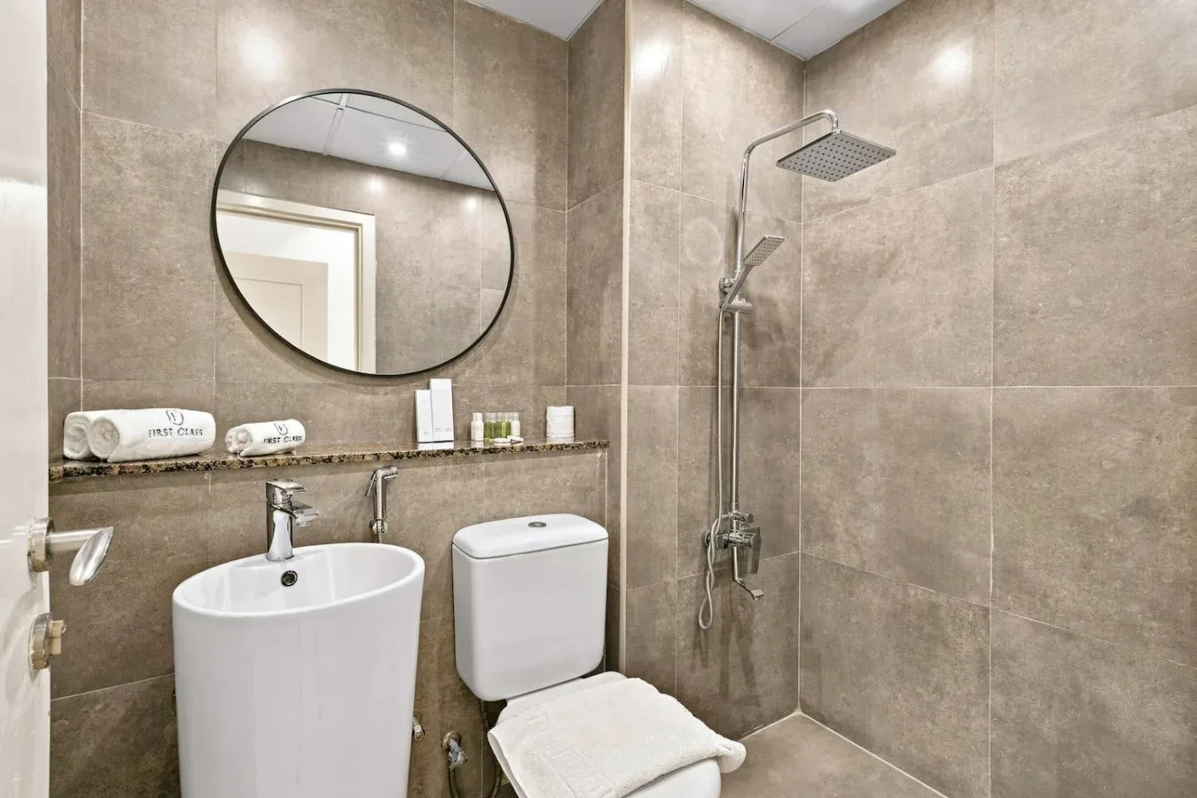 A tiled bathroom with a sink, toilet, and shower.
