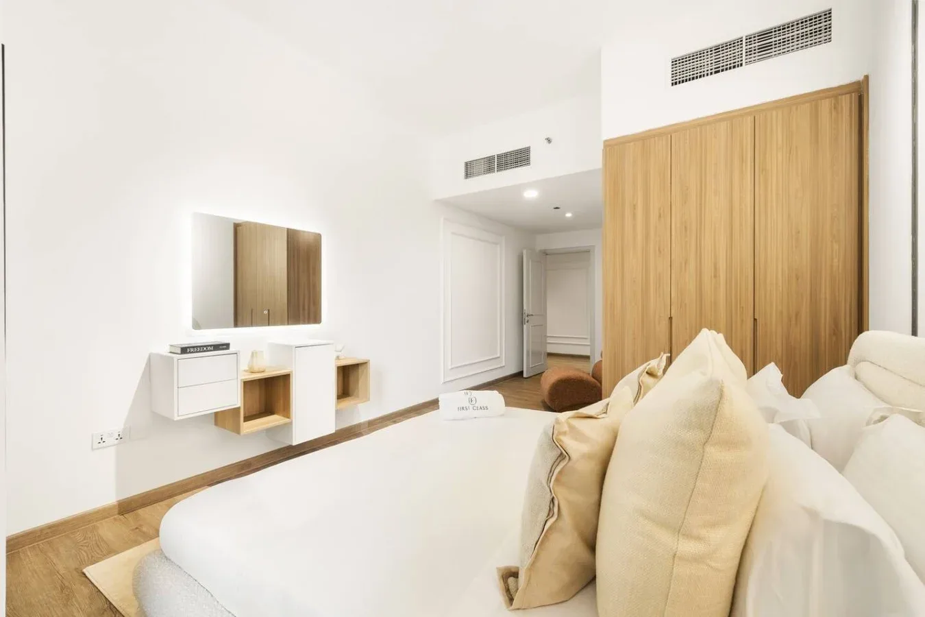 A bright bedroom with a large bed and light-colored bedding.