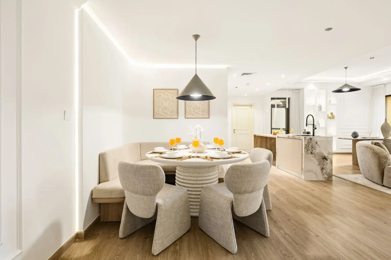 A bright dining area with a set table beside an open kitchen.