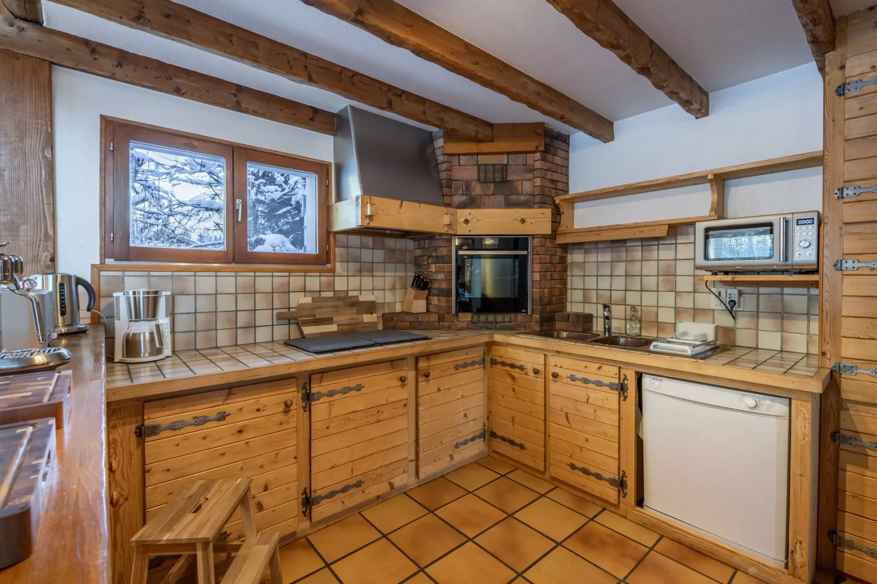 Una cocina rústica con gabinetes de madera, encimeras de azulejos y horno integrado.