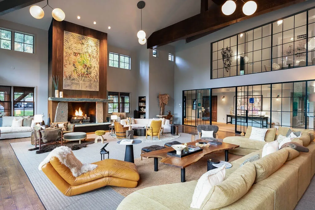 A spacious living room with seating arranged around a central fireplace.