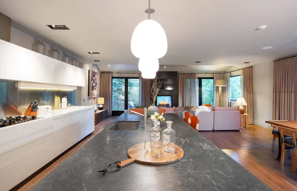An open-plan kitchen and living area with a dining table and seating.